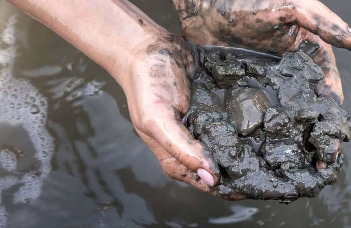 woman holding sludge in hands