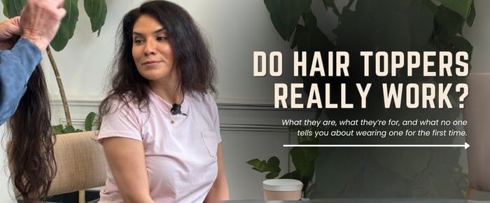 Woman with thinning hair looks at a hair topper during a demo, exploring if hair toppers really work.