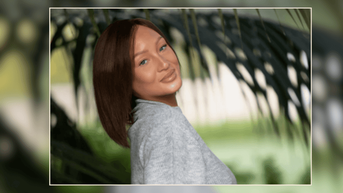 Woman outdoors wearing a low-density wig, smiling and enjoying the natural surroundings.