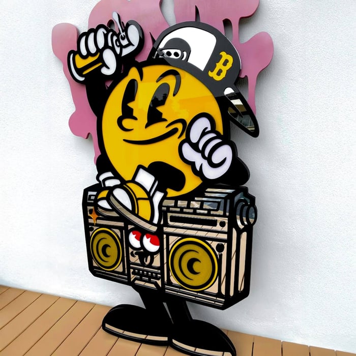 The Spray Your Love 3D Wall Art by Giant Sculptures features a cartoon-style yellow character in a cap, smiling and holding spray paint, with one foot on a boombox, set against pink graffiti shapes for bold street style.