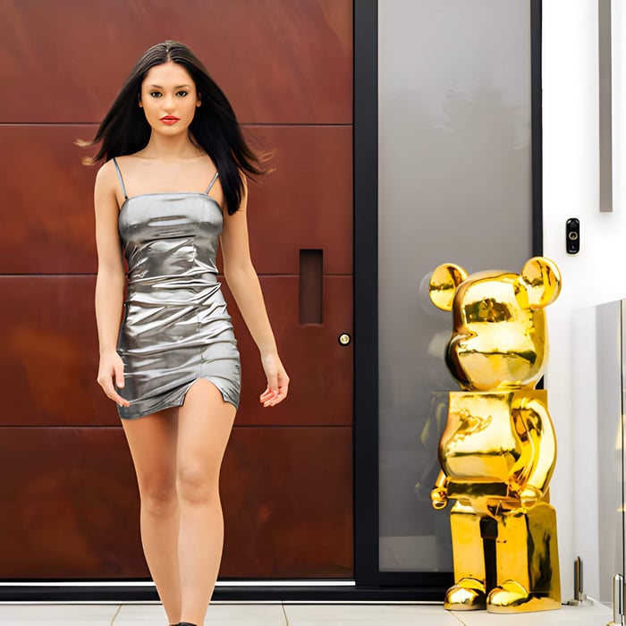 135cm gold bear sculpture standing outdoors beside a modern entrance, paired with a woman in a silver dress, showcasing luxury and contemporary design.