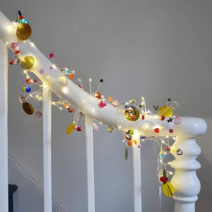 a white stair banister wrapped with pretty fairy lights