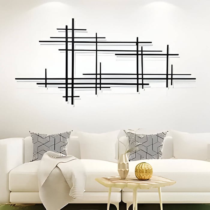 a minimal living room with a black abstract metal wall decor above a cream sofa