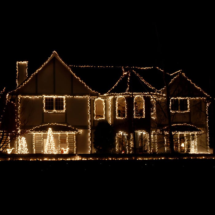 an exterior of a house at nighttime, decorated with Christmas lights