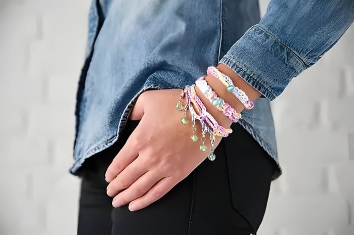 a person wearing 3 crochet friendship bracelets