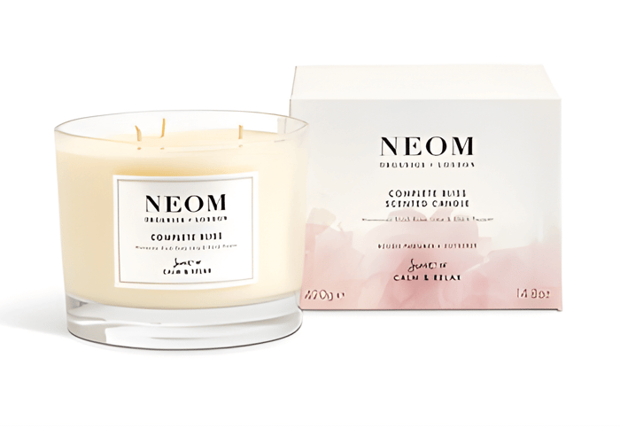 a candle next to a pink and white box