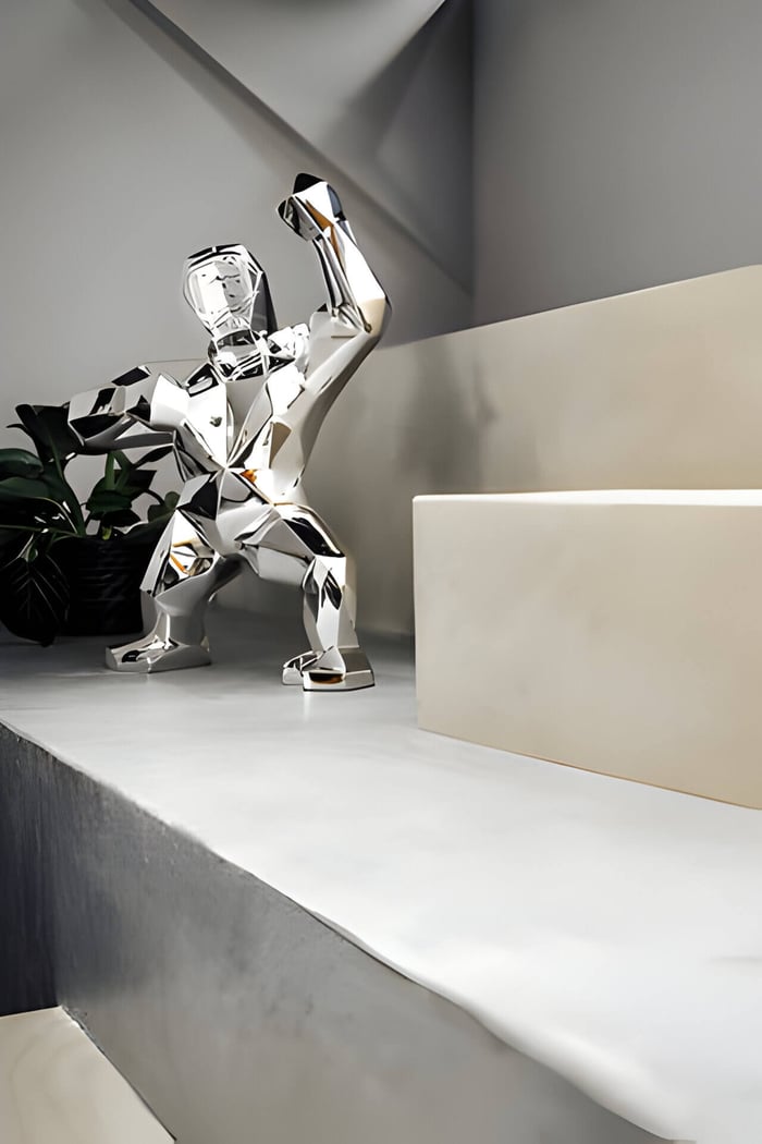 a chrome gorilla sculpture on modern shelf