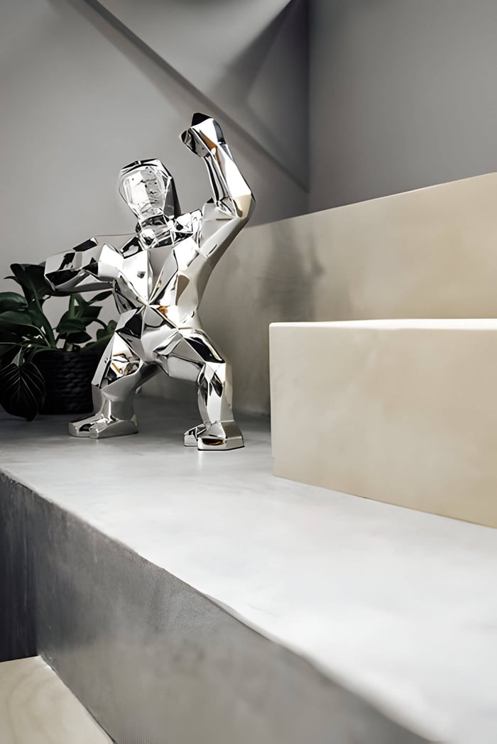 giant bears chrome gorilla sculpture on a bathroom window sill