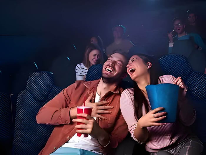A young couple laughing at the cinema