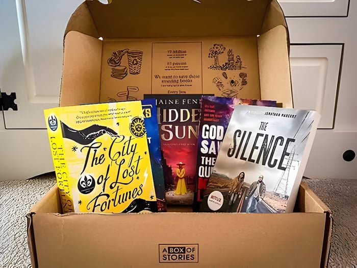 a cardboard box with 4 fiction books inside