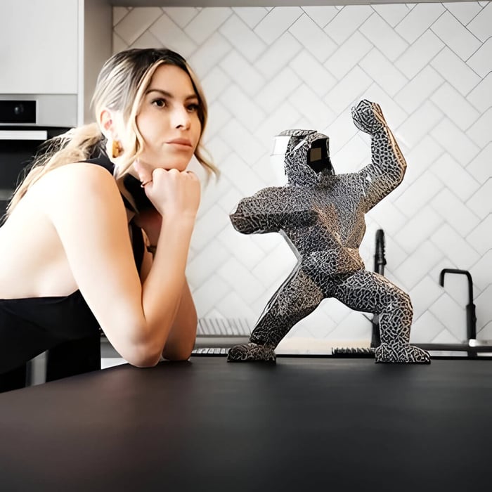 A lady leaning on a counter next to a magma giant bear figurine