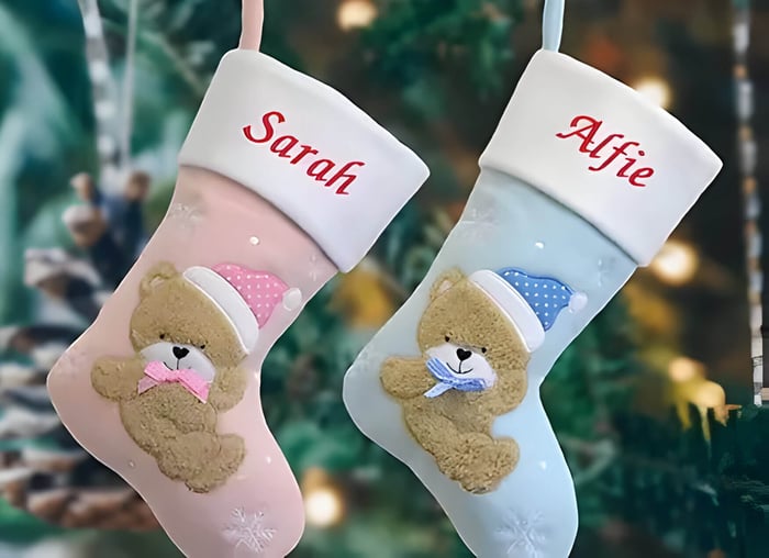 2 Christmas stockings with names on, one pink one blue
