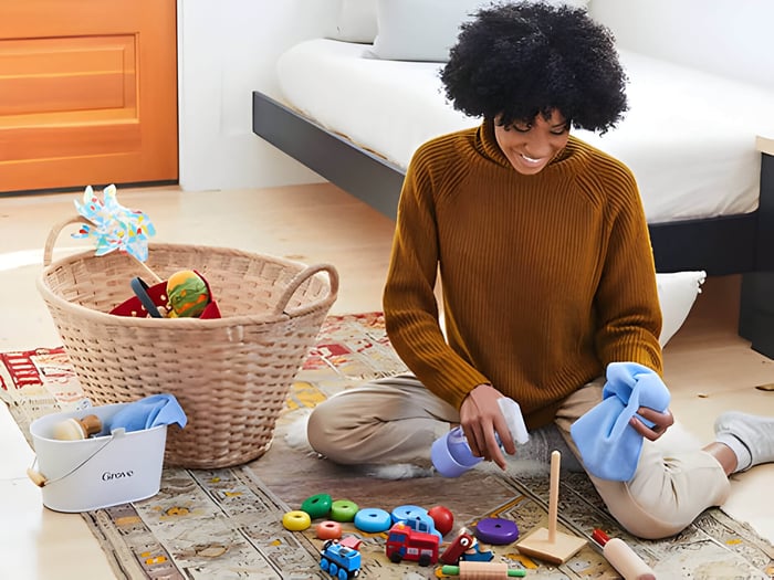 A mum with cleaning products cleaning baby toys