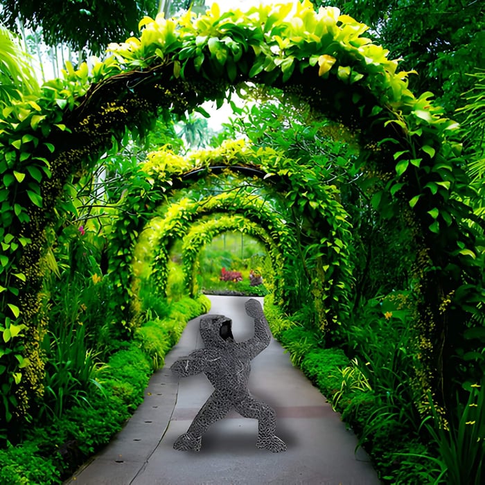 a gorilla sculpture inside a green archway in a garden