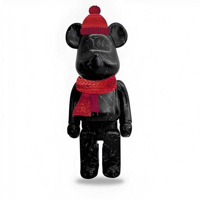 A black giant bear sculpture in a red hat and scarf
