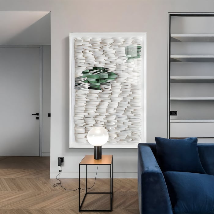 A modern living room with a vertical White & Green Acrylic Box 3D Paper Wall Art featuring layered white circular paper elements and a streak of green accents, adding sculptural texture and depth to a minimalist interior.