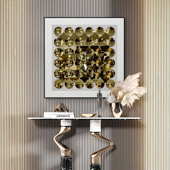 Luxury interior with framed gold mirror disc acrylic 3D wall art above a modern marble console table, styled with pampas grass in metallic vase.