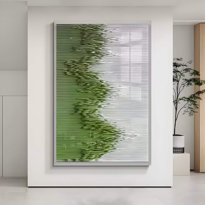 Large vertical 3D wall art with carved wood ridges forming a flowing green and white abstract pattern, displayed in a bright modern interior with minimalist decor and a potted plant.