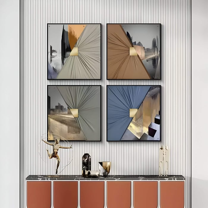 Set of four square 3D wall art pieces combining cityscape photography with folded leather textures and gold accents, arranged in a grid above a modern sideboard with sculptural decor.
