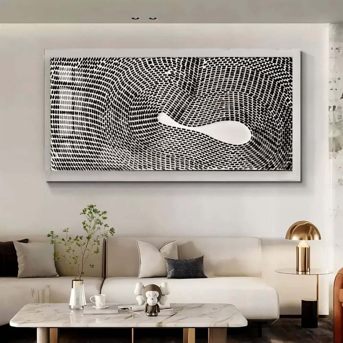Large black-and-white patterned artwork in a white frame displayed above a sofa in a modern lounge area.