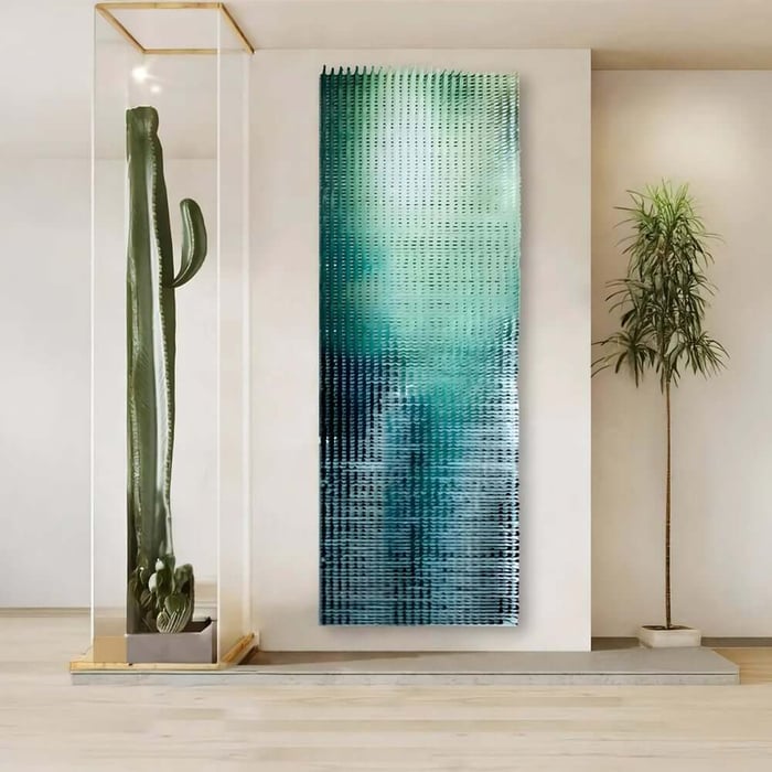 Tall narrow teal and silver abstract hallway artwork positioned beside a large cactus and plant.
