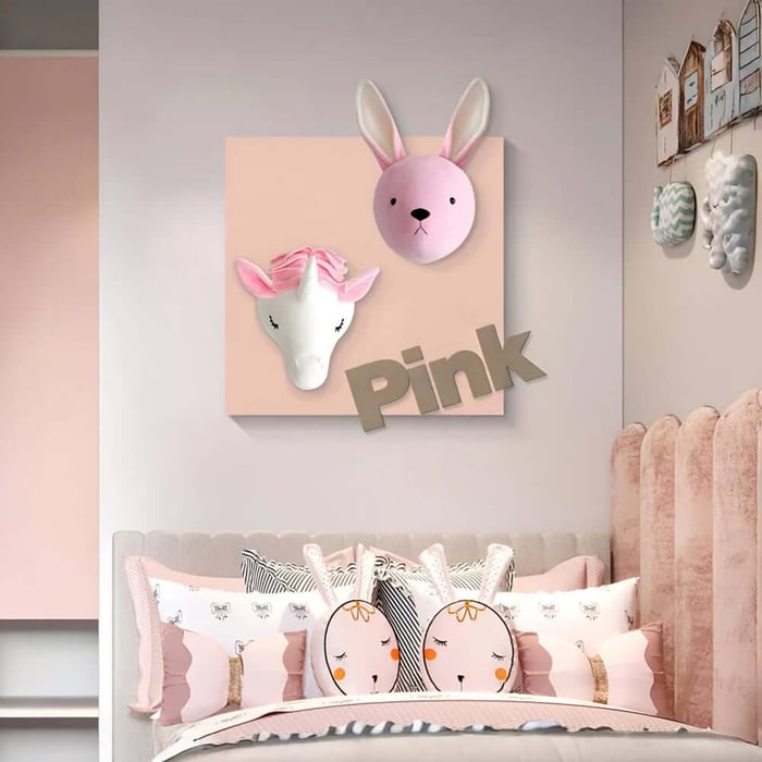 Pink-themed children’s bedroom with a wall plaque featuring 3D bunny and unicorn heads above a bed with matching cushions.