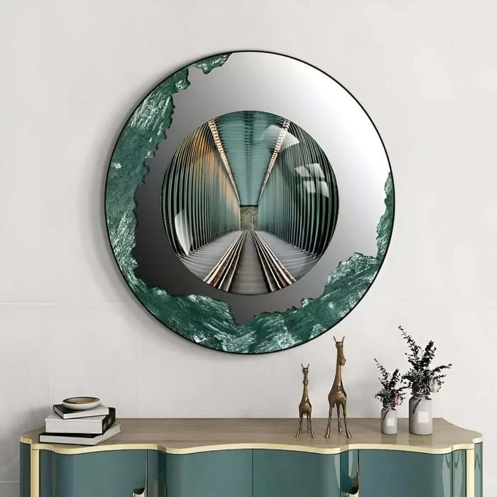 Round wall art with a mirrored tunnel illusion in the centre and a green textured border above a console table with décor.