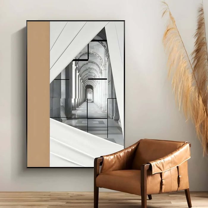 Framed corridor architecture art print with geometric overlays and a beige side block above a leather chair.