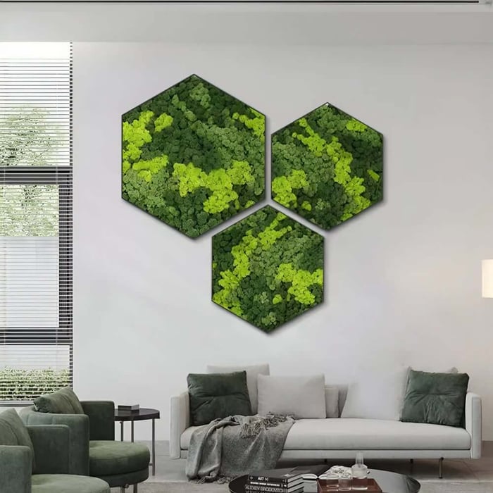 Hexagonal green moss wall art arranged in a cluster on a white wall above a modern living room sofa with green and gray cushions and chairs.
