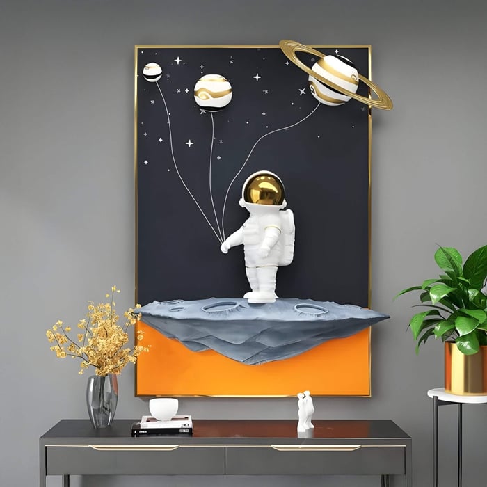 Playful astronaut 3D artwork holding balloon-like planets on a black and orange panel, placed above a sleek console table.
