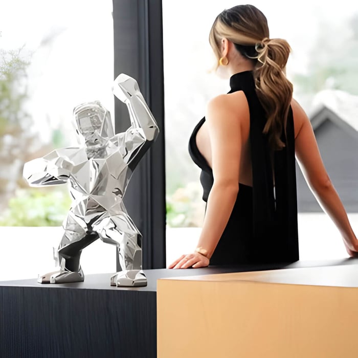 A chrome gorilla sculpture and a lady facing back