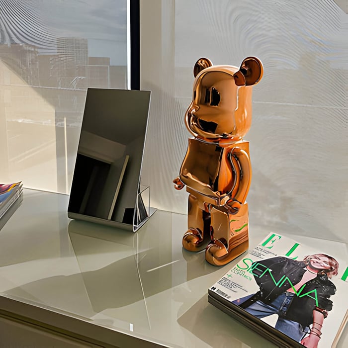 a rose gold giant bear sculpture on a modern white desk