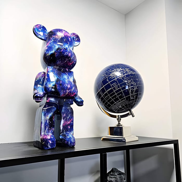 a blue and purple cosmic effect giant bear sculpture on a table next to a blue globe