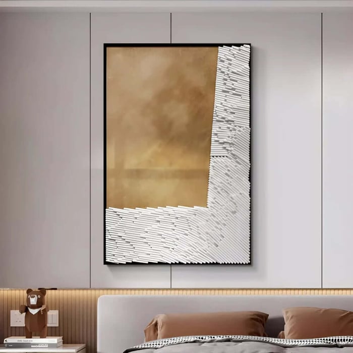 Contemporary bedroom with a large vertical abstract artwork featuring a warm golden centre framed by textured white rods, hanging above a bed with brown pillows and neutral bedding.