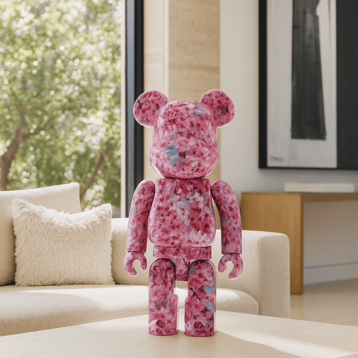 Sakura Bloom Bear Sculpture 70cm in pink floral resin design displayed on a modern living room coffee table with sofa and window background.