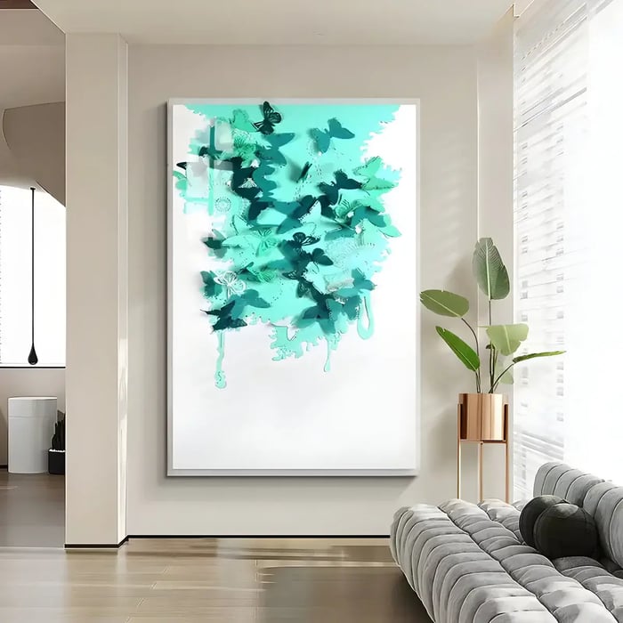A striking abstract piece of wall art featuring turquoise and teal butterflies, with fluid paint drips on a white background, displayed above a plush sofa in a contemporary living room.