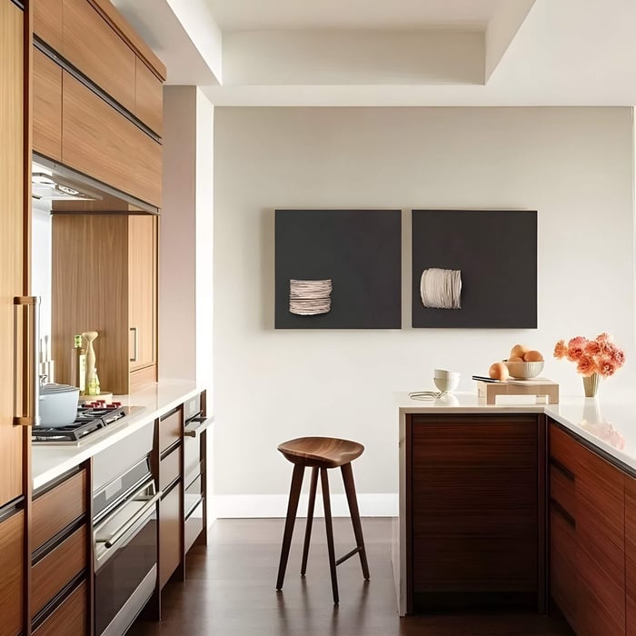 Warm-toned kitchen with dual square artworks showcasing neutral yarn textures on dark backdrops above a breakfast bar.