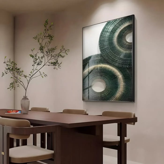 Large green circular abstract artwork in dining room – A tall framed green abstract art piece with circular textures displayed above a wooden dining table.