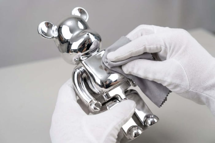 Caring for a collectible figurine with cotton gloves and soft cloth — proper figurine maintenance