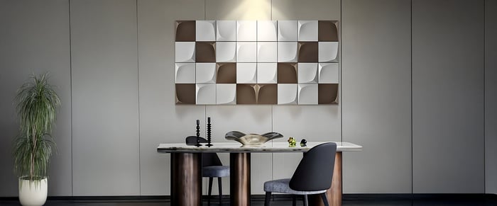 Minimalist office with geometric wall art, modern desk, and chair under focused spotlight.