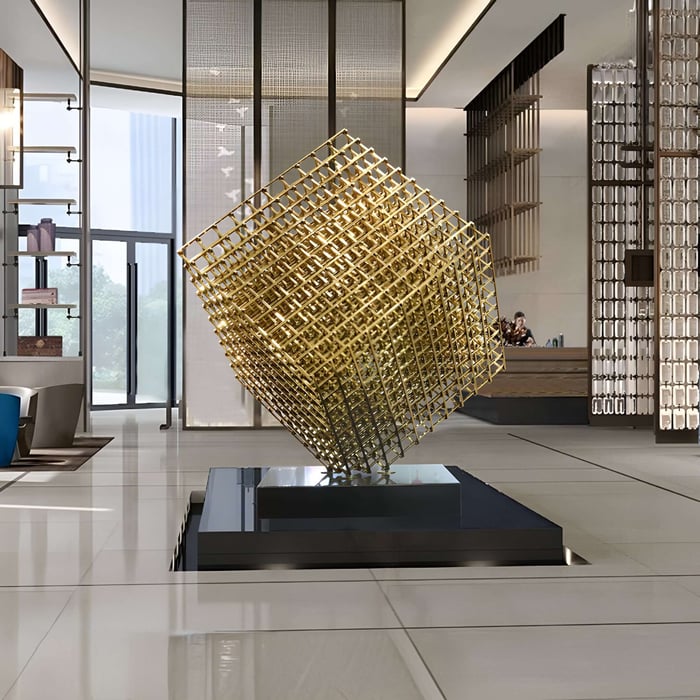 Large golden cube lattice sculpture in a spacious modern lobby.