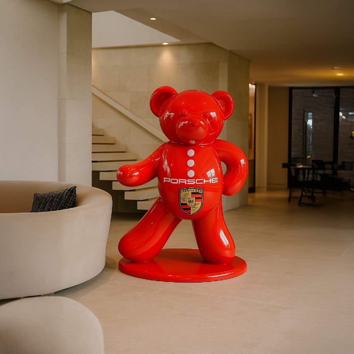 165 cm Gacko Porsche Bear Sculpture – glossy red bear statue with Porsche crest, standing in a minimalist living room