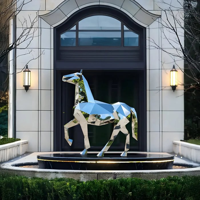 A set of sleek, high-shine metal flamingo sculptures arranged in a modern outdoor setting.