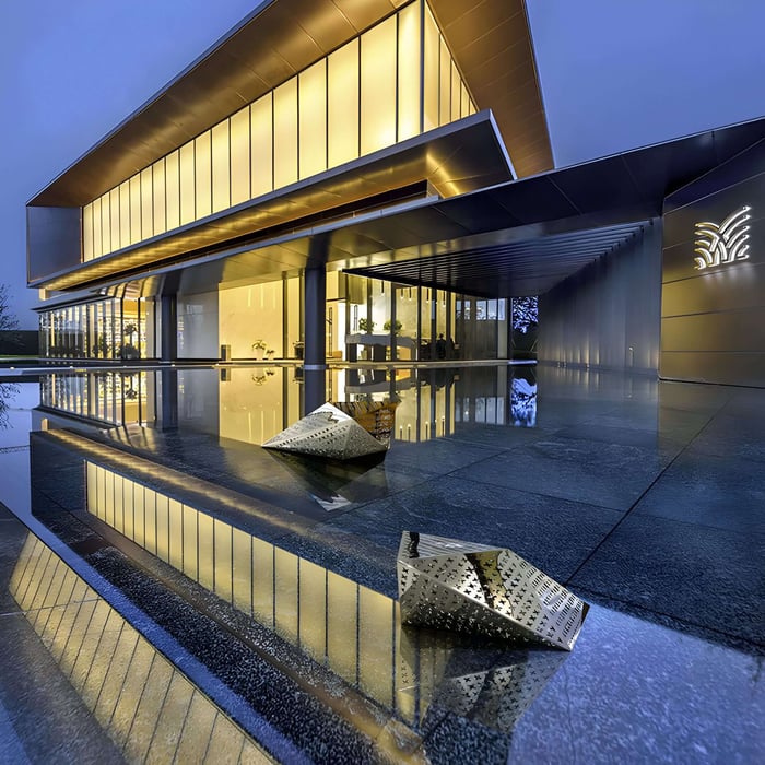 The Edge Geometric sculpture displayed beside a contemporary building, blending harmoniously with the architecture and reflecting the surrounding light.