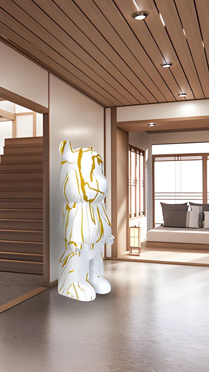 A white and gold Giant Bear sculpture in a neutral hallway