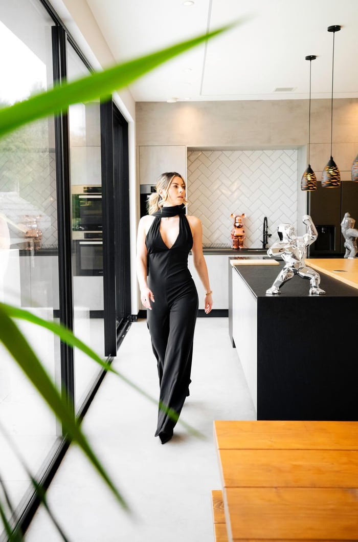 A woman walking past a chrome gorilla sculpture in a modern home