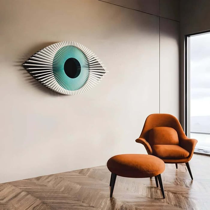 Modern 3D hallway wall art in eye design above orange accent chair in minimalist corridor.