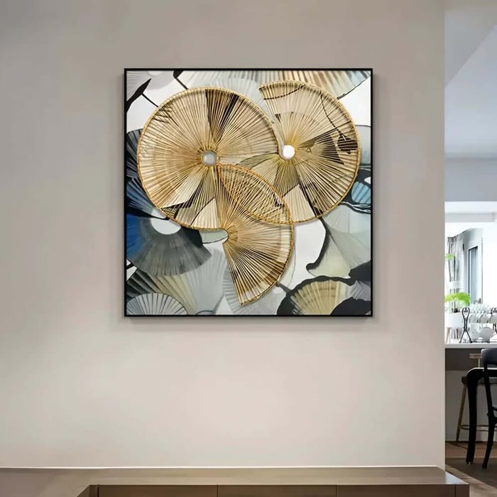 Square wall art with gold, spiral fan-like forms over a muted gray-blue background in a modern hallway.