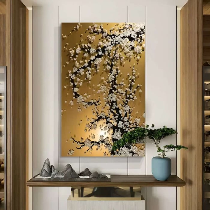 Gold hallway artwork with blossoming tree design above a console table with bonsai plant.