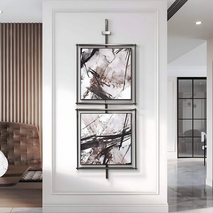 Modern hallway with two abstract black-and-white zen art paintings vertically mounted on a sleek frame against white paneling.